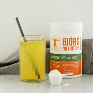 Glas met Björg Nutrition poeder en de pot met scoop ernaast