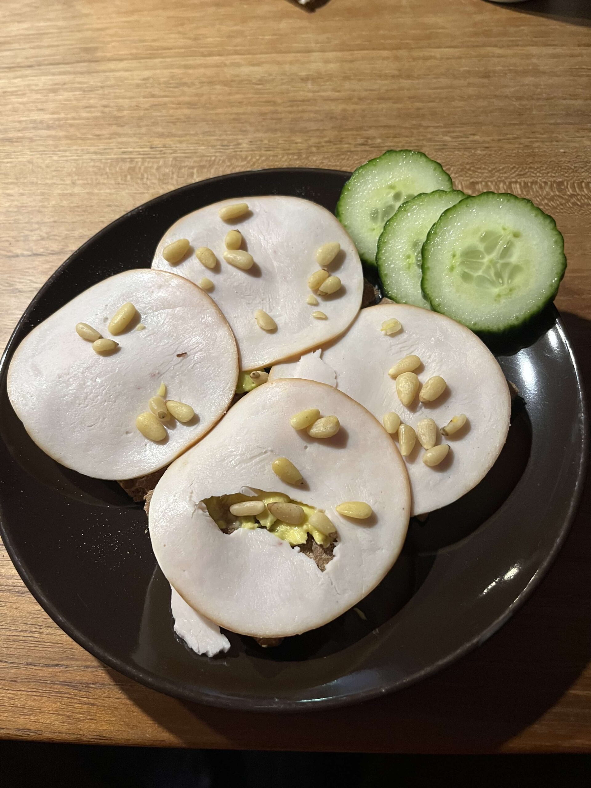 Volkoren crackers met avocado, kipfilet en pijnboompitten